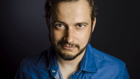 Das Bild zeigt den Schauspieler Tino Leo vor einem schwarzen Hintergrund. 