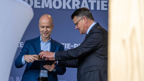 Jörg Eigendorf (links) nimmt den Walter-Lübcke-Demokratie-Preis 2022 in Wolfhagen stellvertretend für seine Frau, die mit dem Preis ausgezeichnete ZDF-Journalistin Katrin Eigendorf, von Ministerpräsident Boris Rhein entgegen.