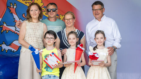 Ministerpräsident Rhein und seine Frau mit einer Drillingsfamilie