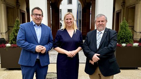 Zwei Männer und eine Frau stehen nebeneinander