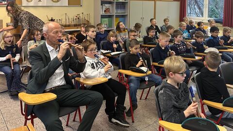 Erwachsener und Grundschüler mit Blockflöte